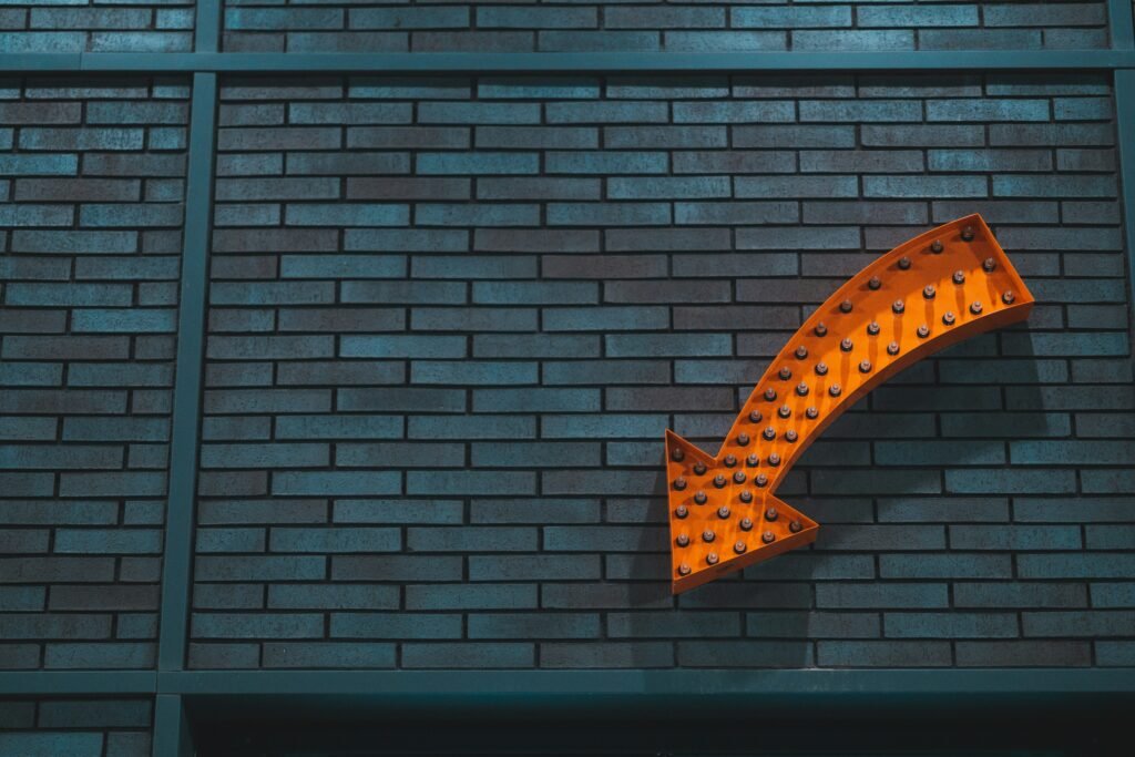 Orange arrow on dark brick wall